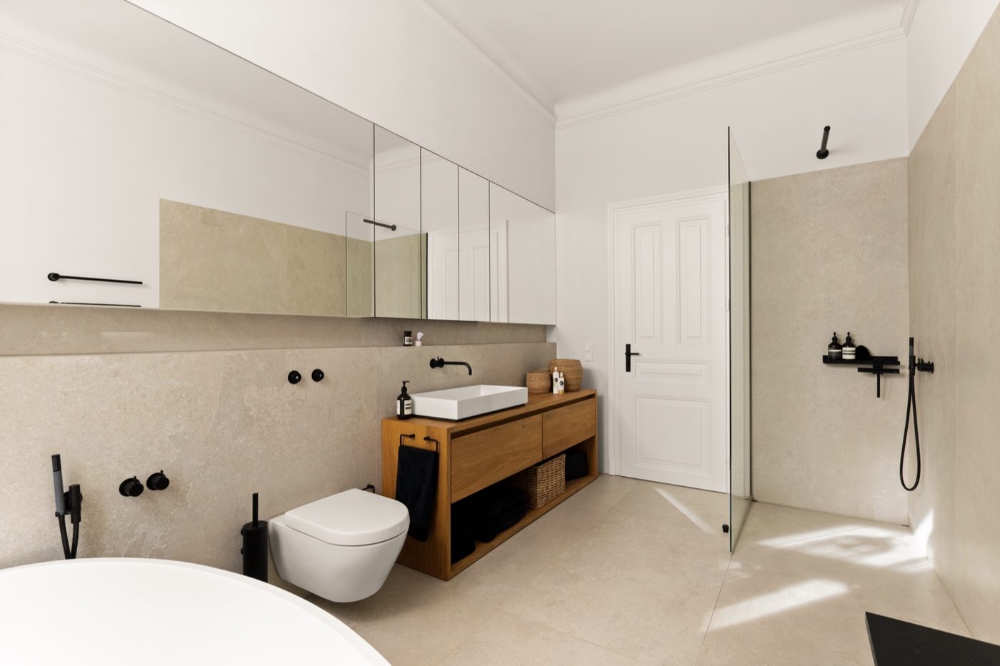 Natursteinbad mit freistehender Badewanne und Vola-Armaturen